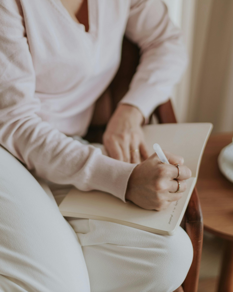 Hands resting on an open notebook, ready to journal