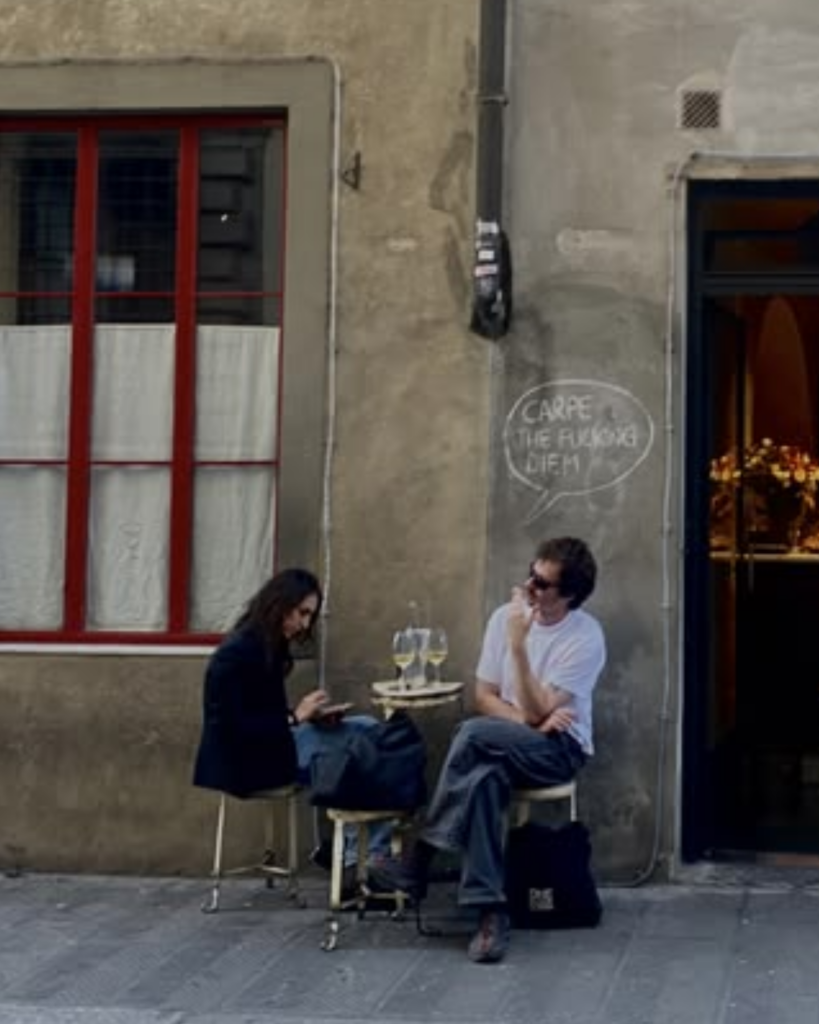 Friends gathered outside a stone building, talking and laughing