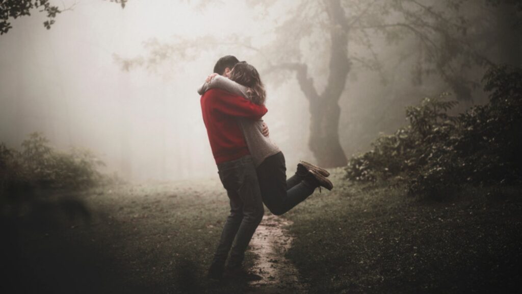 Couple embracing on a foggy forest path