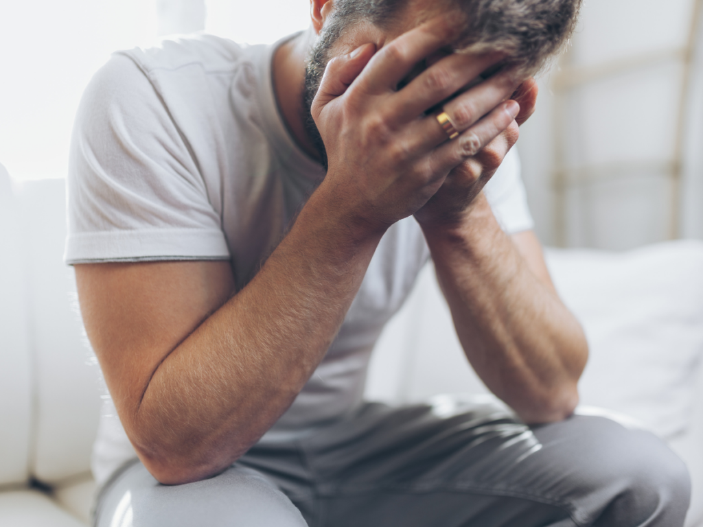 Man covering his face in grief