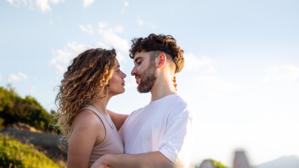 Couple embracing outdoors, looking into each other's eyes