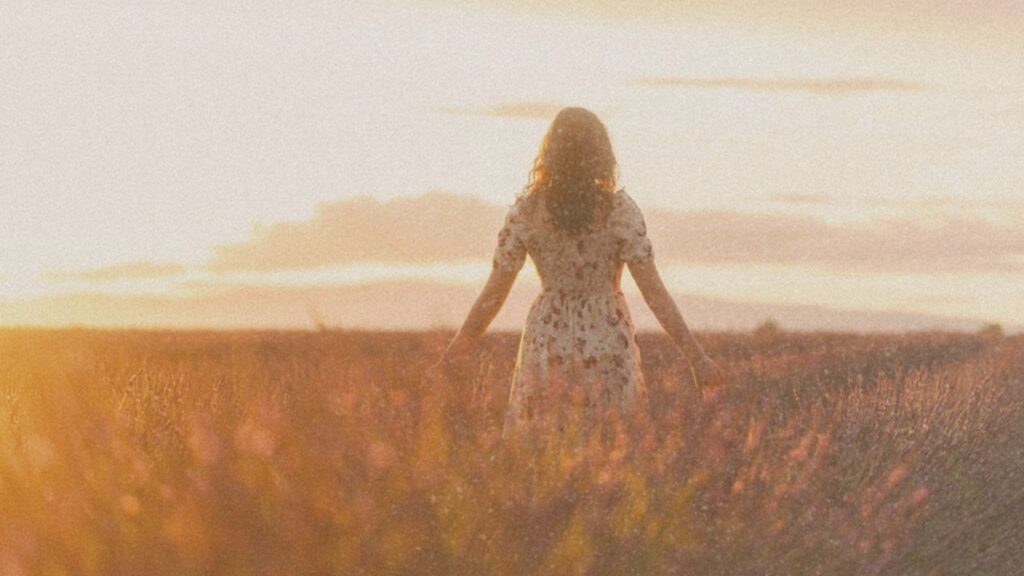 Woman in a field at sunset