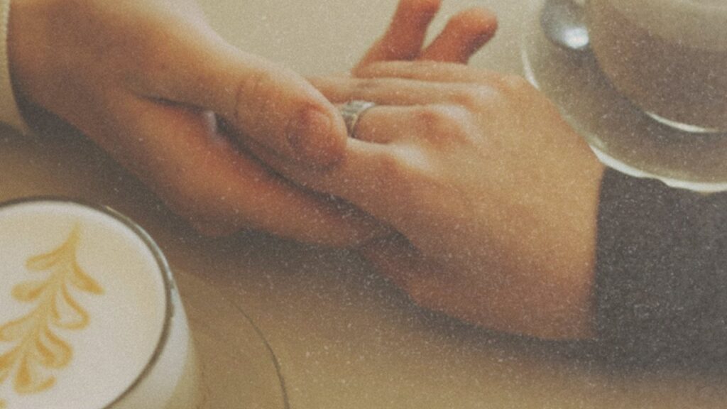 Hands touching over cappuccinos