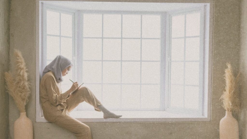 Woman journaling in a window seat