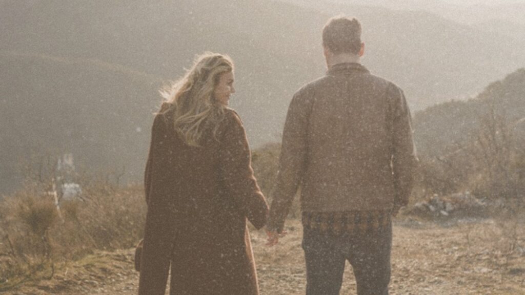 Couple walking hand in hand in the hills
